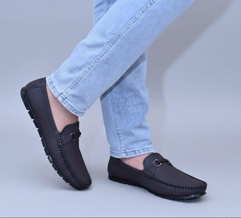 Person wearing Zawa Monarcha loafers and light blue jeans on a plain surface