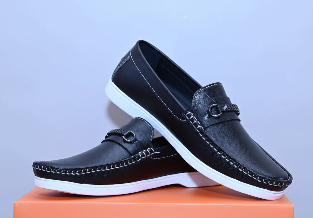 ZAWA Regent Black loafers on an orange box with a light background