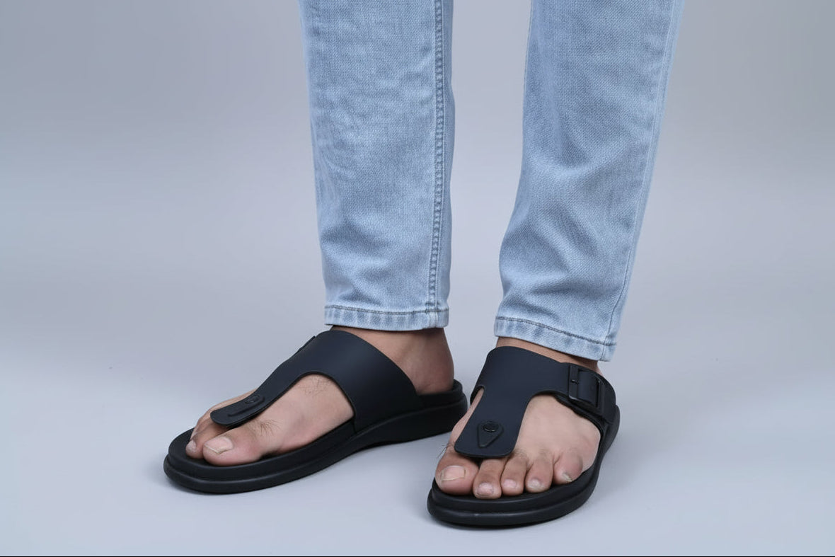 Person wearing zawa rivano black sandals on a plain background