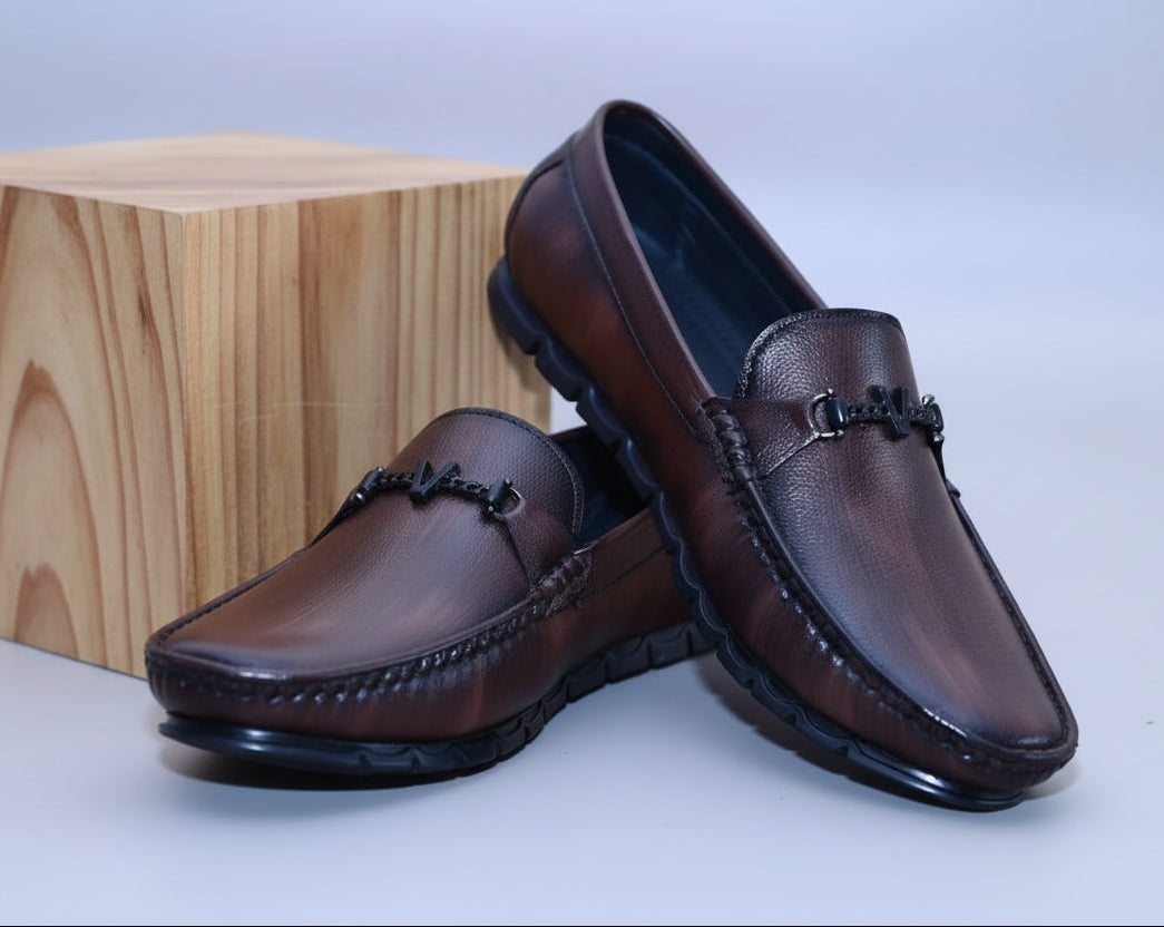 Zawa Valoris Brown loafers leaned on a wooden surface with a plain background