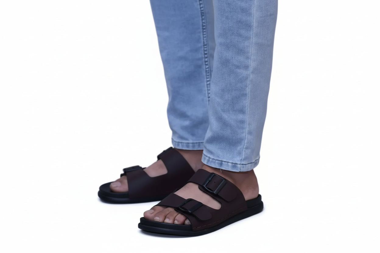 Brown zawa vereno sandals worn with light blue jeans on a plain background