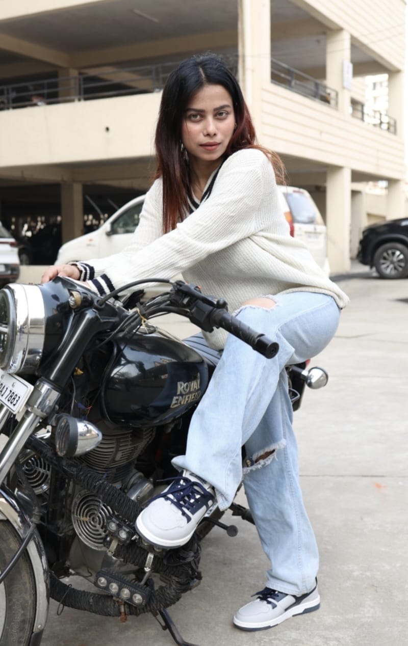 Girl sitting on a motorcycle in an urban setting wearing zawa coreflex sneaker