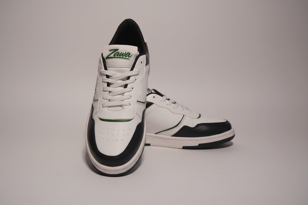 White and black zawa noctyra sneakers with green accents on a grey background
